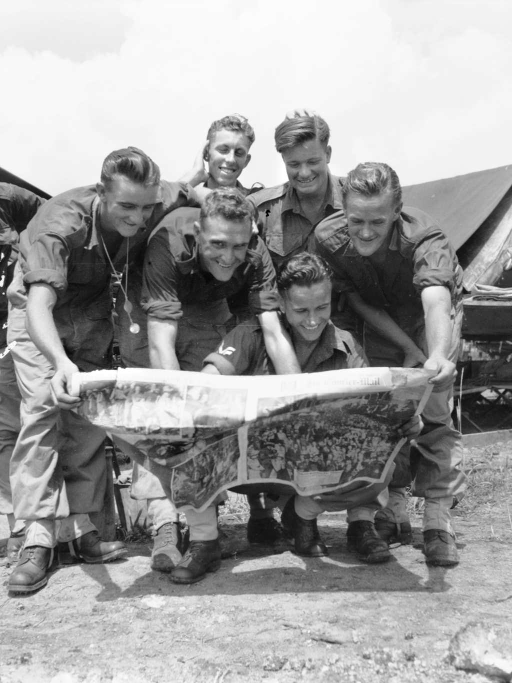 Australian soldiers reading news of the Pacific victory at Wewak Point, August 1945