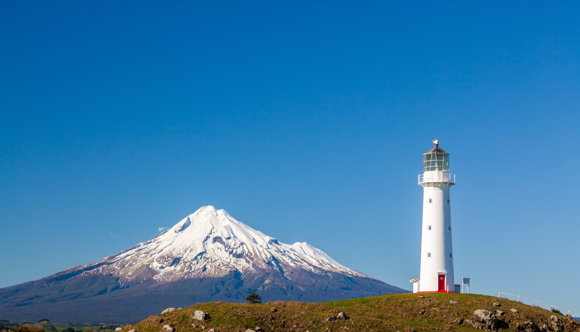 Cape Egmont Lighthouse with Mount Taranaki behind it, New Zealand