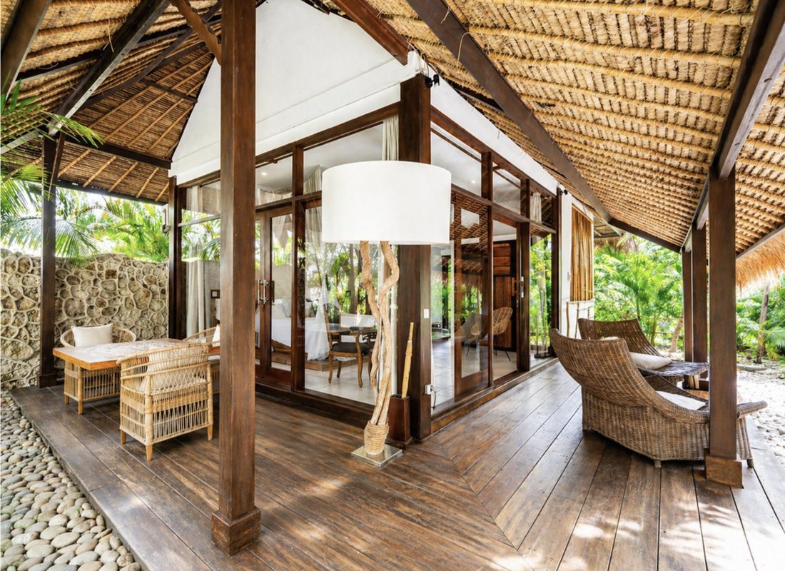 Open-air bungalow porch with rattan furniture