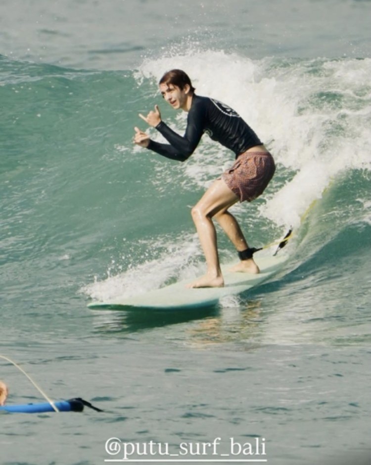 A student riding a wave during a Putu Surf Bali instruction