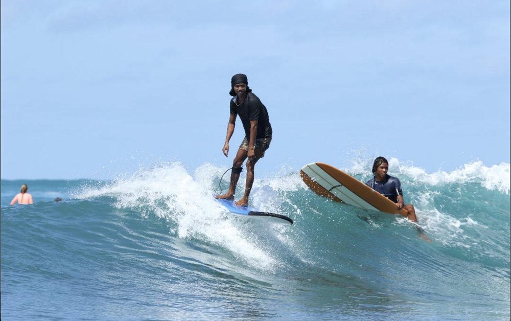 Surf Local Lombok guide surfing alongside another rider
