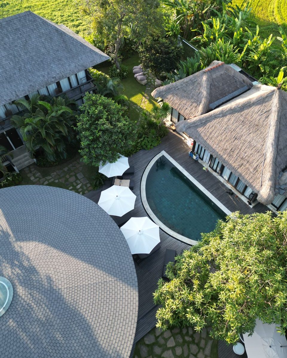 Aerial view of WaveHouse's pool and thatched-roof property in Canggu