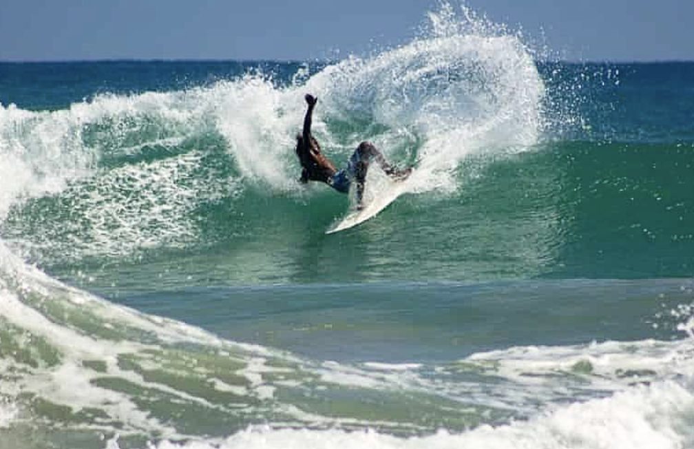Surfer carving through a breaking wave in Puerto Viejo