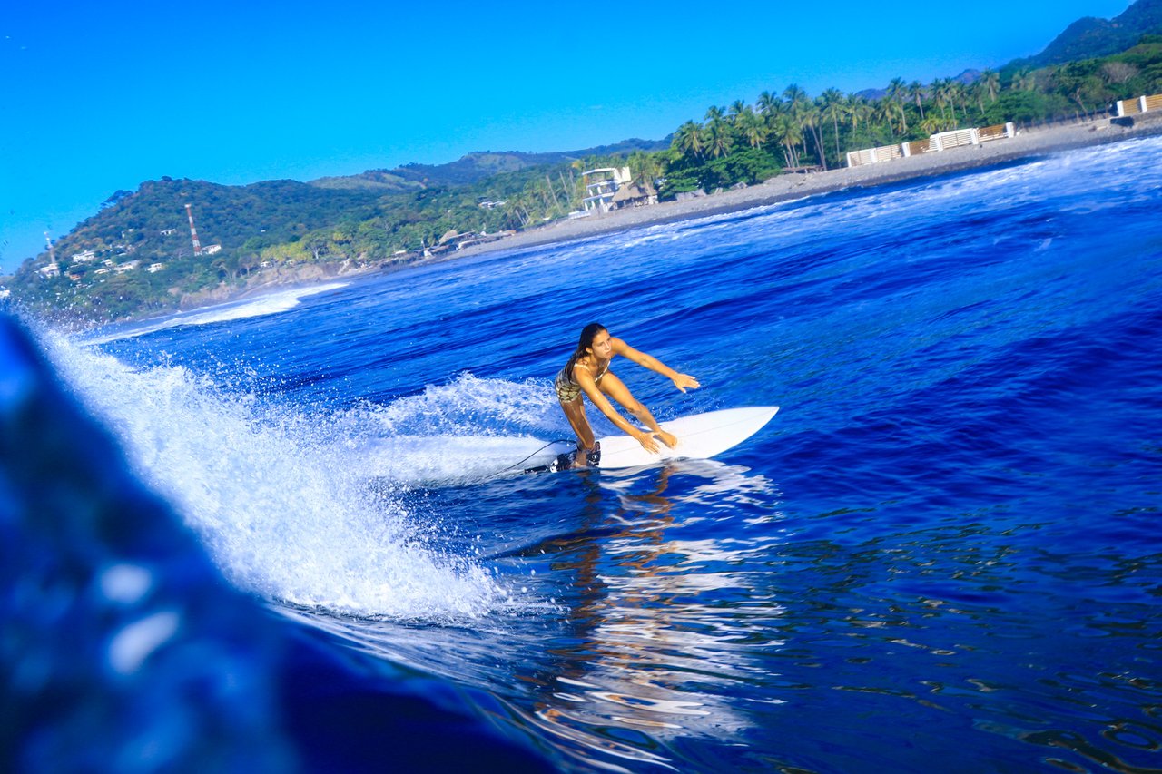 Surfer in the lineup with the coastline visible in the background