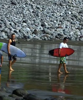 Surfers heading out at Punta Mango