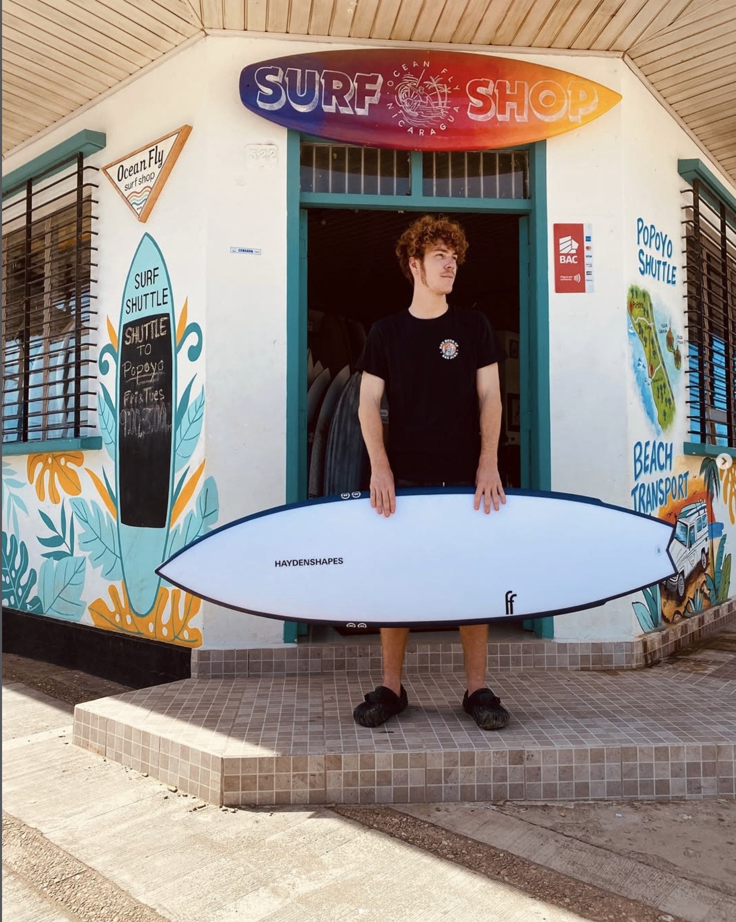 Ocean Fly Surf Shop storefront in San Juan del Sur with a rental board out front