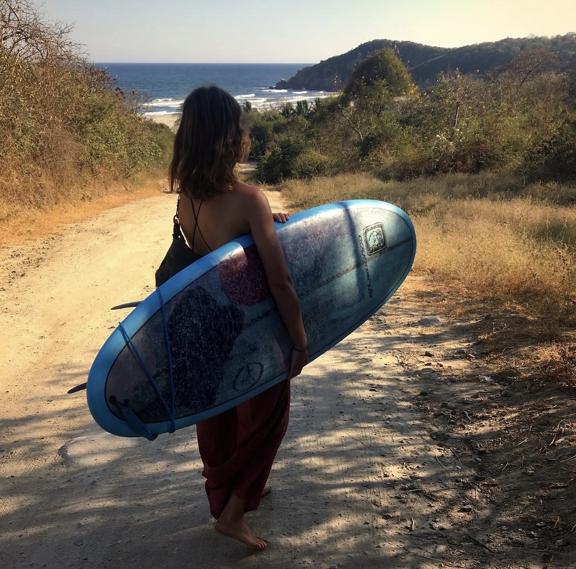 Carrying an Odyboards board down a trail to the beach, Puerto Escondido