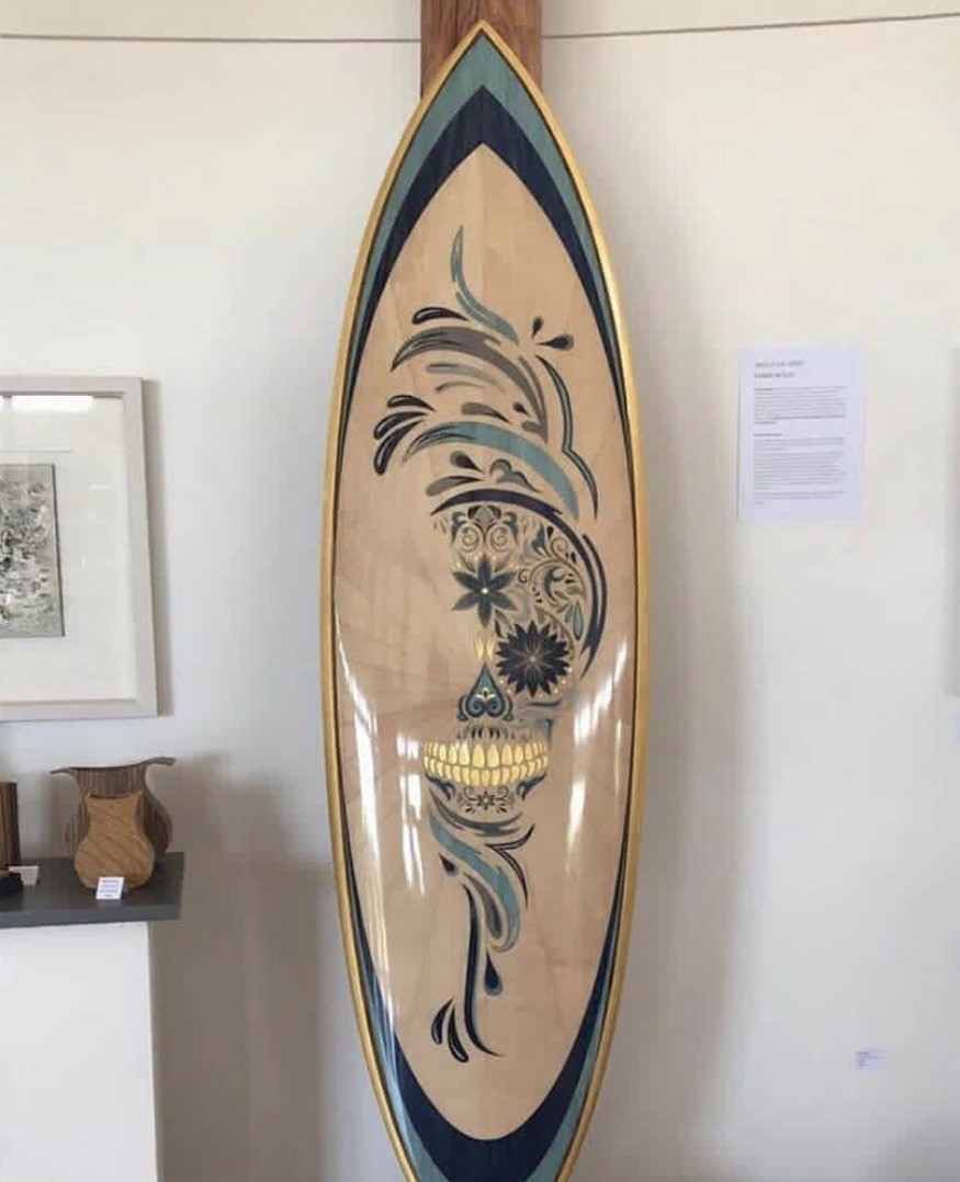 Sugar-skull wood-inlay custom surfboard by Odyboards
