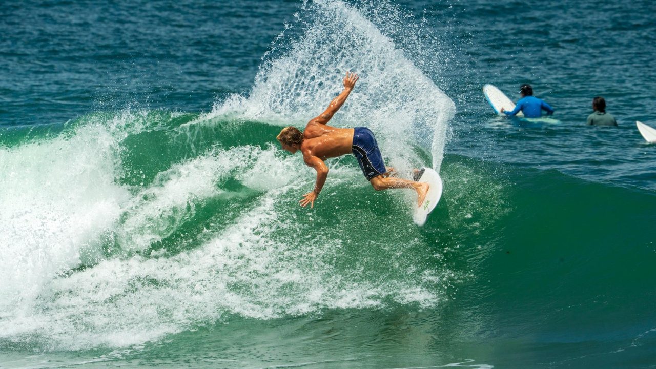 Surfer catching air with the lineup watching, shot by Bocas Is Love