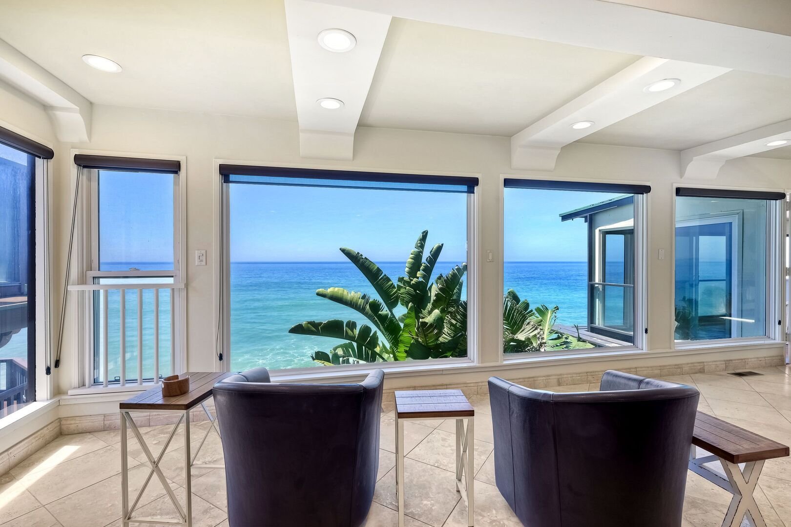 Living room with large windows looking out at the ocean at an Oceanside Haustay home